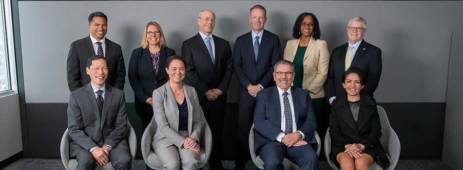 Group of ten board members, four seated in front, 6 standing in back.